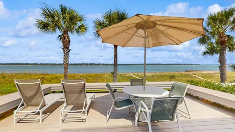 39 Lands End Road. a deck in front of the ocean with furniture