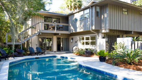 4 Canvasback. a tan, two story house house behind a pool