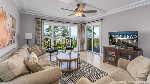Shorewood 408. a tv room with 2 tans sofas, and two upright chairs
