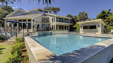 Hilton Head Vacations. a square pool in front of a large house