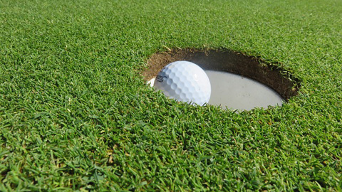 The Design of a. golf ball going into hole